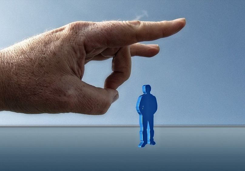 Hand schnippt Figur weg